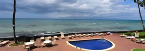 A pool area with lounge chairs and a swimming pool, overlooking a beach with ocean views. - Kaanapali, Kulakane, Spacious 4 BR, Beachfront, Sleeps 14 (Lahaina)