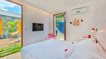 Un dormitorio moderno con una cama grande, un televisor montado en la pared y vistas al exterior.