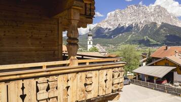 A wooden building with a balcony overlooking a mountainous landscape.