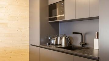 A modern kitchen with stainless steel appliances, a microwave, and a sink.