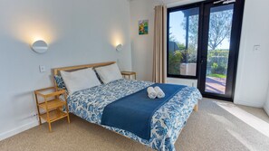 Una camera da letto con un letto, due comodini, una finestra con tende e vista sull'esterno.