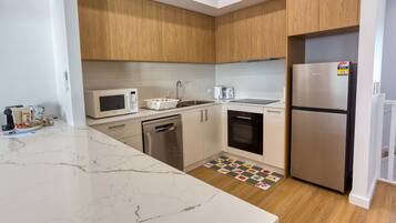 A modern kitchen with a built-in microwave, toaster, and dishwasher.