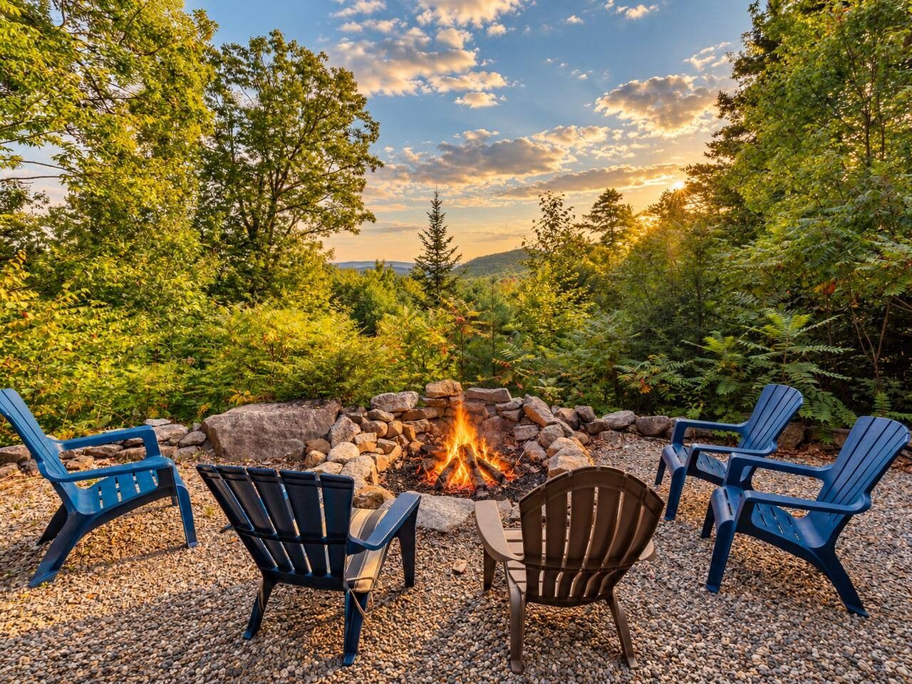 A fire pit surrounded by Adirondack chairs in a natural setting.
