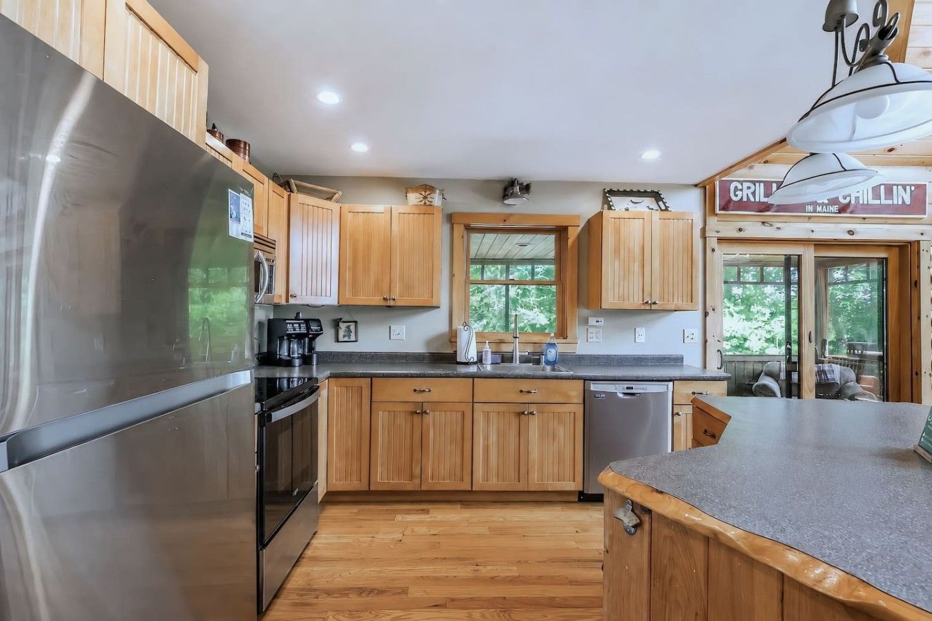 A modern kitchen with wooden cabinets, stainless steel appliances, and a large island.