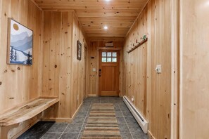 A wooden hallway with a bench, a rug, and a door at the end. - Sleeps 10, Lake View Retreat, with Hot tub & Barrel Sauna (Woodstock)