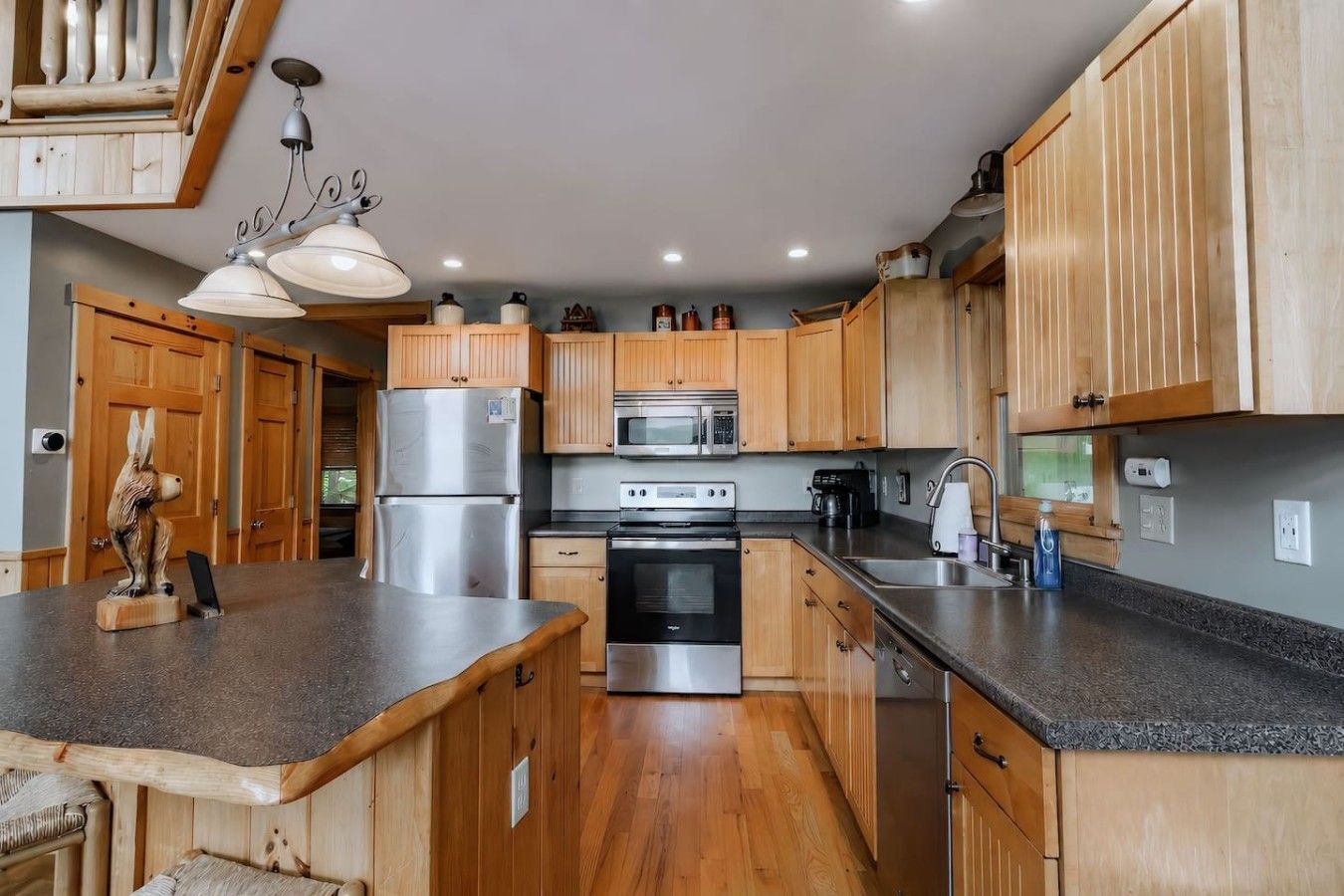 A modern kitchen with wooden cabinets, stainless steel appliances, and a granite countertop.