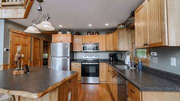 A modern kitchen with wooden cabinets, stainless steel appliances, and a granite countertop.