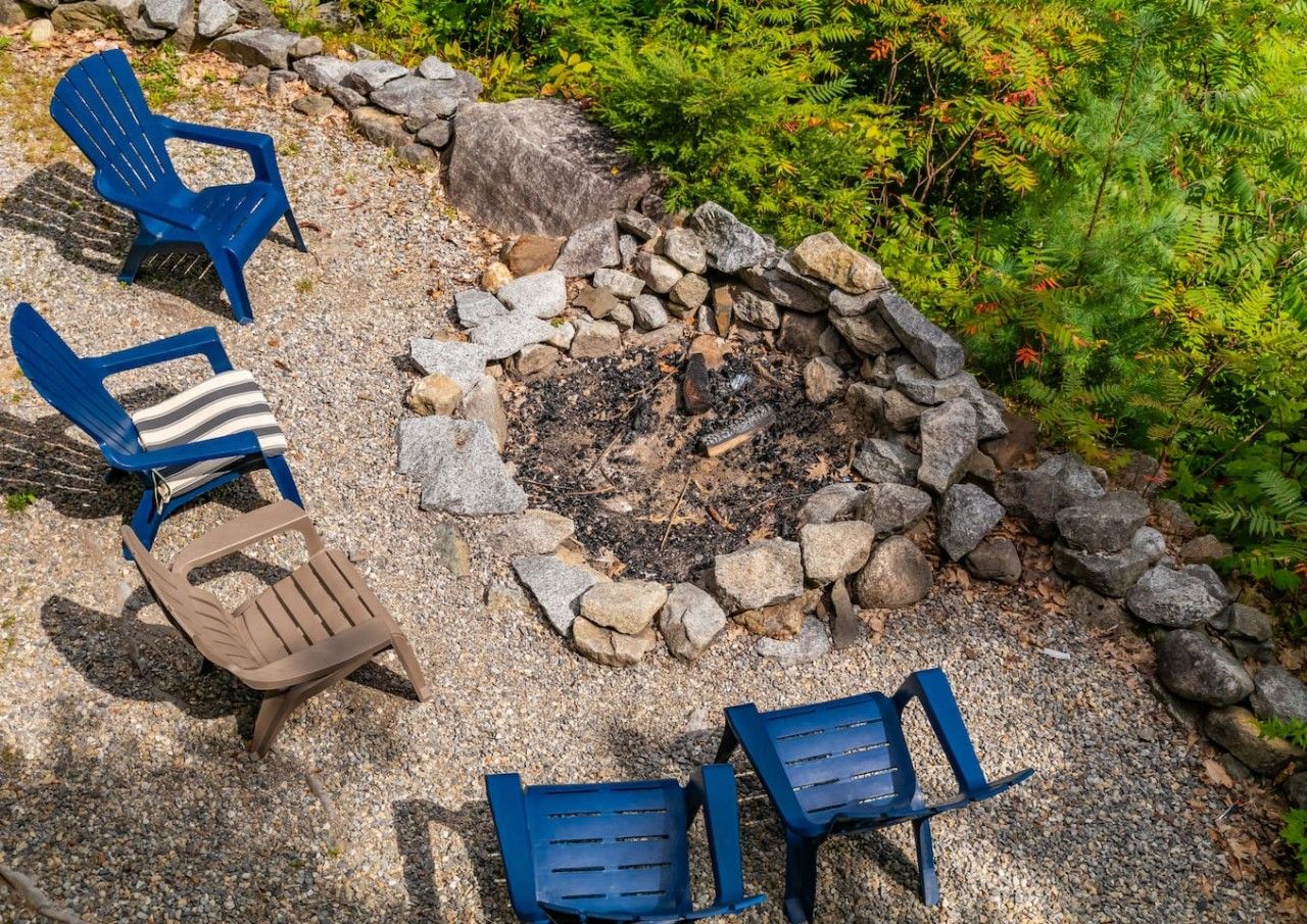 A fire pit surrounded by chairs and rocks.