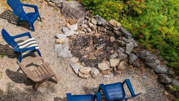 A fire pit surrounded by chairs and rocks.