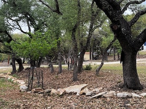 A natural outdoor area with trees, rocks, and a path. - PRIVATE COZY RV FOR RENT; ONLY 2 RVS ON PROPERTY, HOT TUB, CHARCOAL GRILL;SERENE (Canyon Lake)