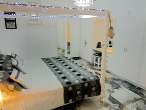 A room with a bed, a desk, and a wardrobe.
