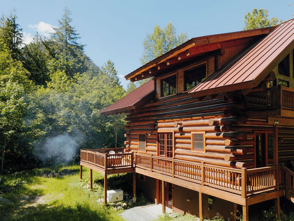 Eine Blockhütte mit Balkon, umgeben von Bäumen.
