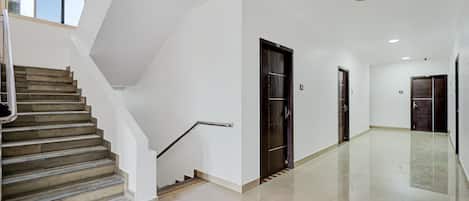 A modern interior with a staircase, a hallway, and doors.