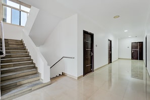 A modern interior with a staircase, a hallway, and doors.
