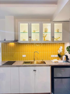Eine moderne Küche mit Spüle aus Edelstahl, eingebautem Ofen und Kühlschrank.