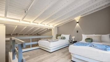 Ein Schlafzimmer mit zwei Betten, einer Holzbalkendecke und einem Nachttisch mit Lampe.