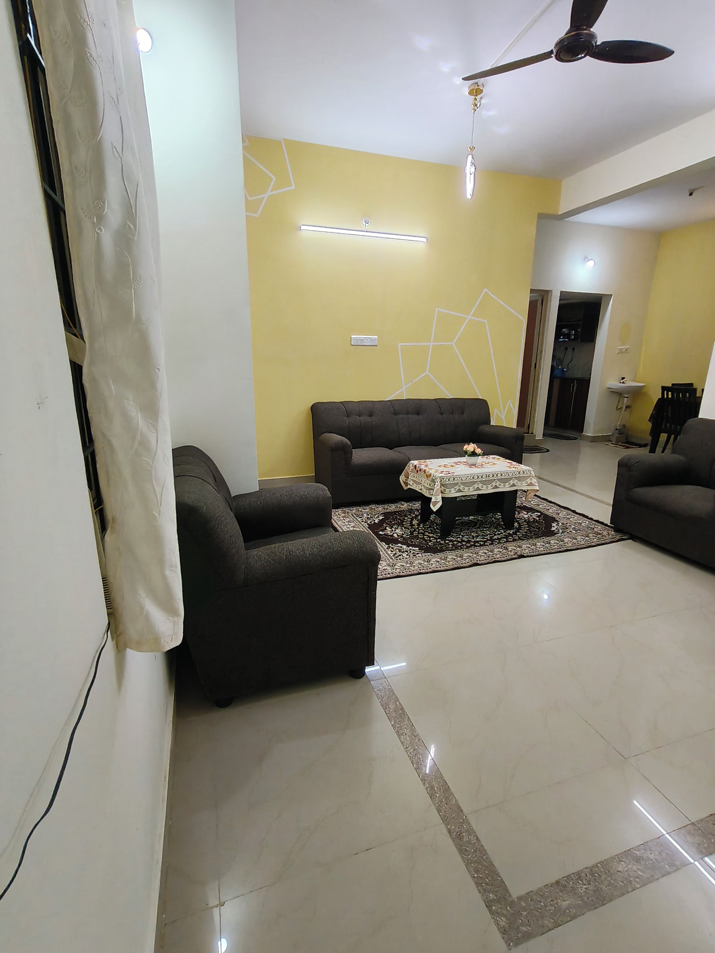 A living room with a sofa, a coffee table, and a ceiling fan.