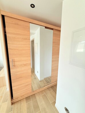 A room with a sliding wooden wardrobe and a white door.