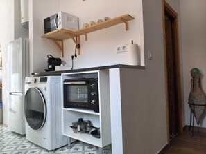 A compact kitchen with a washing machine, a microwave, and a built-in oven. - El Porky del Almirante, a little cottage near the sea. Enjoy it with your pet. (Las negras)