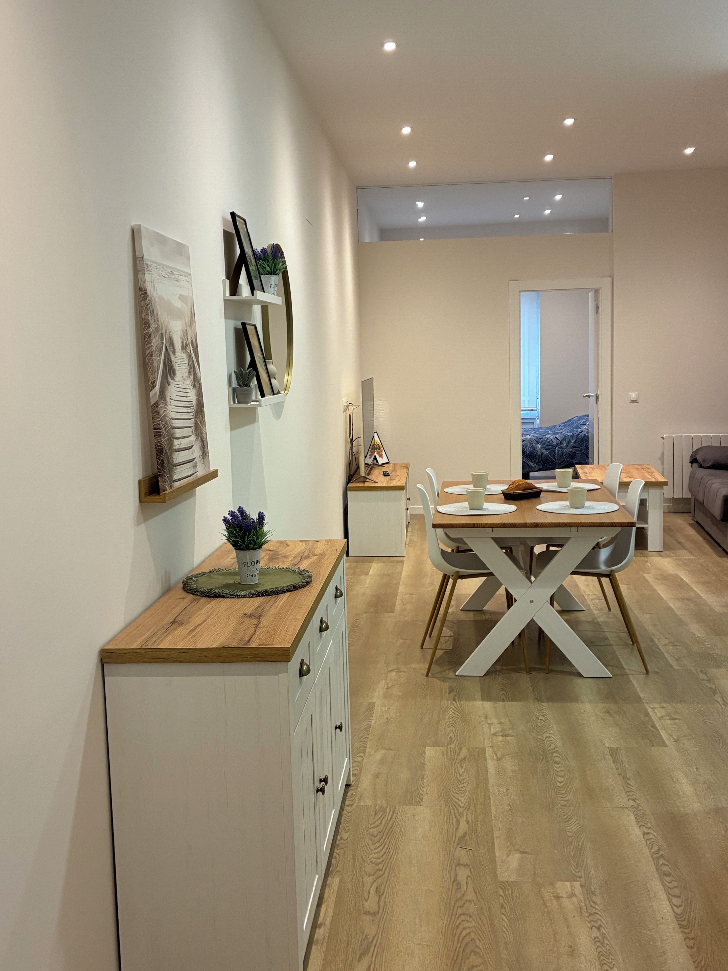 Een moderne keuken met een eetgedeelte, houten kasten en uitzicht op de woonkamer.