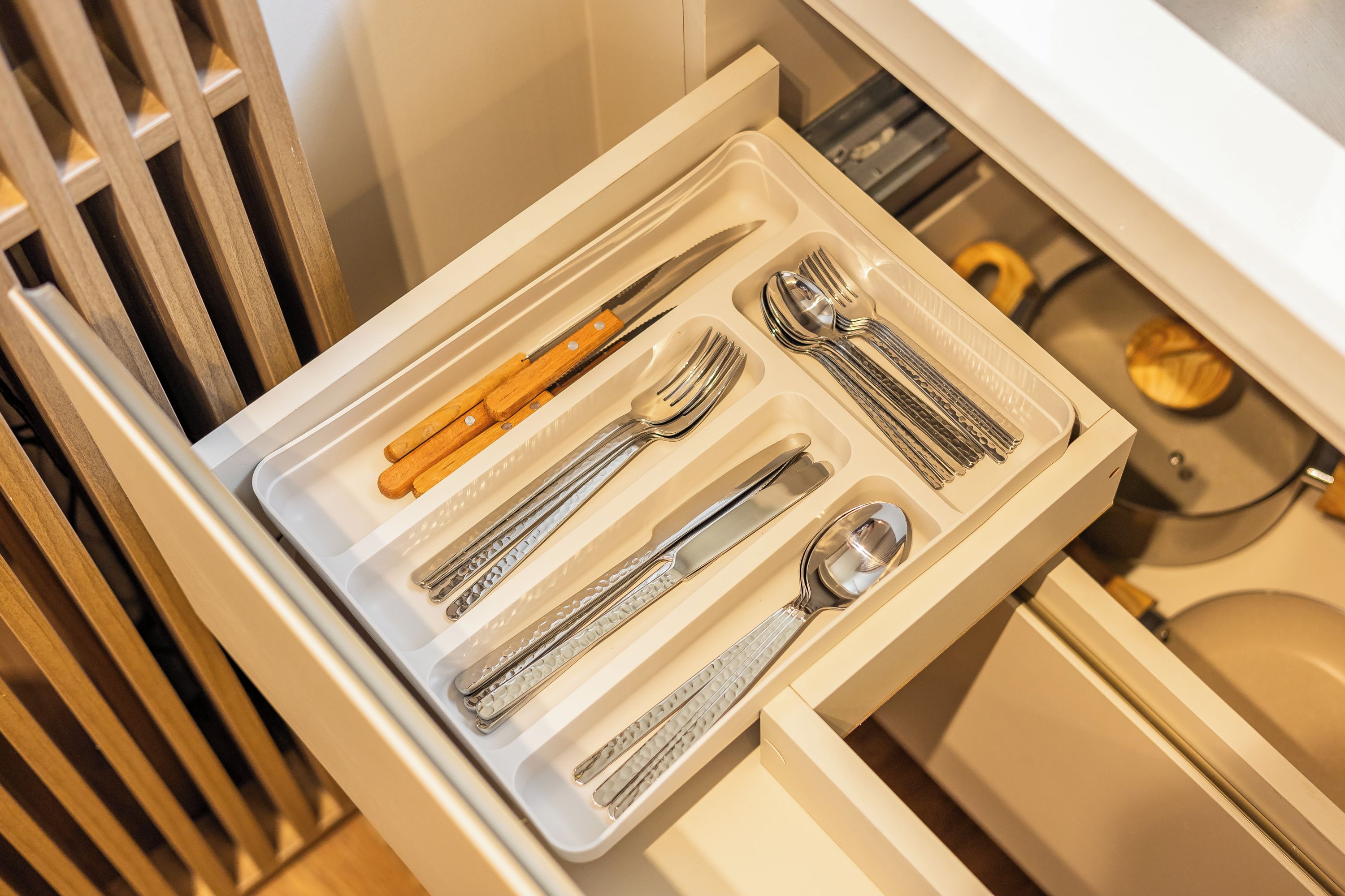 A drawer with neatly arranged cutlery including forks, knives, and spoons.