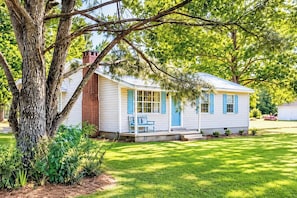 A single-story house with a porch, a bench, and a large tree in front. - The Birdhouse, Pet-Friendly 3BR by Velvet Ditch (Oxford)