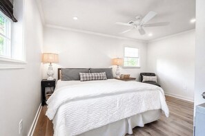 A bedroom with a bed, two bedside tables, a ceiling fan, and a window. - The Birdhouse, Pet-Friendly 3BR by Velvet Ditch (Oxford)