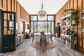 A dining area with a round table, chairs, and a chandelier. - The Barn, Pool + Private Theater by Velvet Ditch Villas (Oxford)