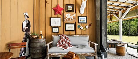 Ein rustikales Interieur mit einer Holzwand, einer Couch, einer Bank und einem Esstisch.