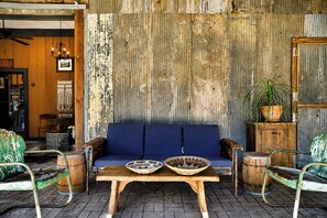 Ein rustikales Interieur mit einem blauen Sofa, einem Holztisch und Metallstühlen.