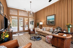 A spacious living room with a large window, a fireplace, and a comfortable seating area.