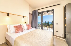 Une chambre d’hôtel avec un lit, un balcon doté d’une table et de chaises, et une vue sur la mer.