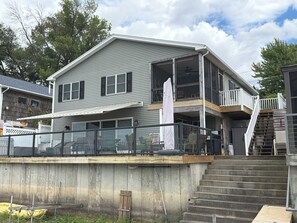 A two-story building with a balcony and a covered outdoor seating area. - Monthly 2-bedroom lake house 3 miles to St.Albans city-5 miles to I-89/hospital. (Georgia)