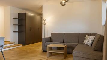 A modern living room with a sofa, a coffee table, and a floor lamp.
