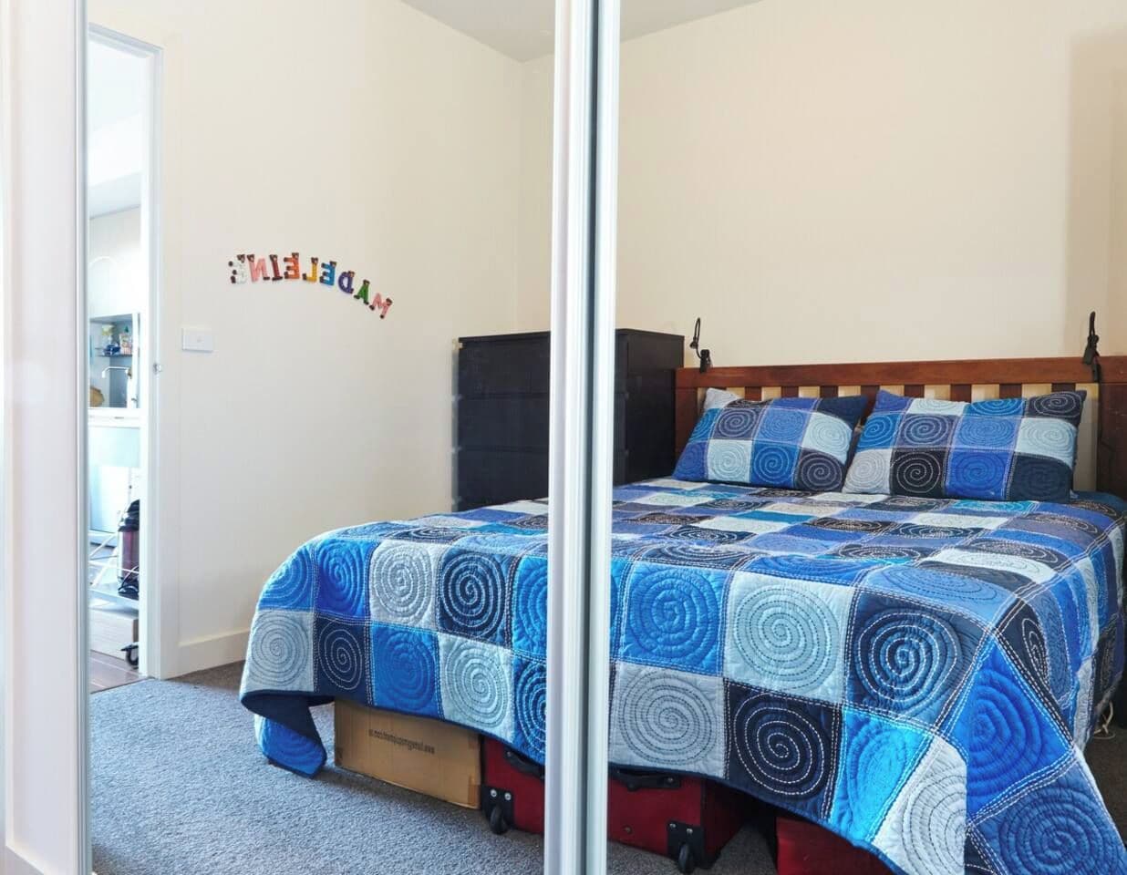 Un dormitorio con cama, armario y puerta que da a otra habitación.