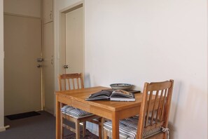 Ein Essbereich mit einem Holztisch und Stühlen, einem Buch und einer Schüssel auf dem Tisch.