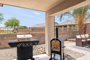 Un patio exterior con una parrilla y zona de estar.