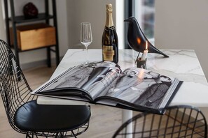 Un magazine sur une table, avec une bouteille de champagne et une bougie.