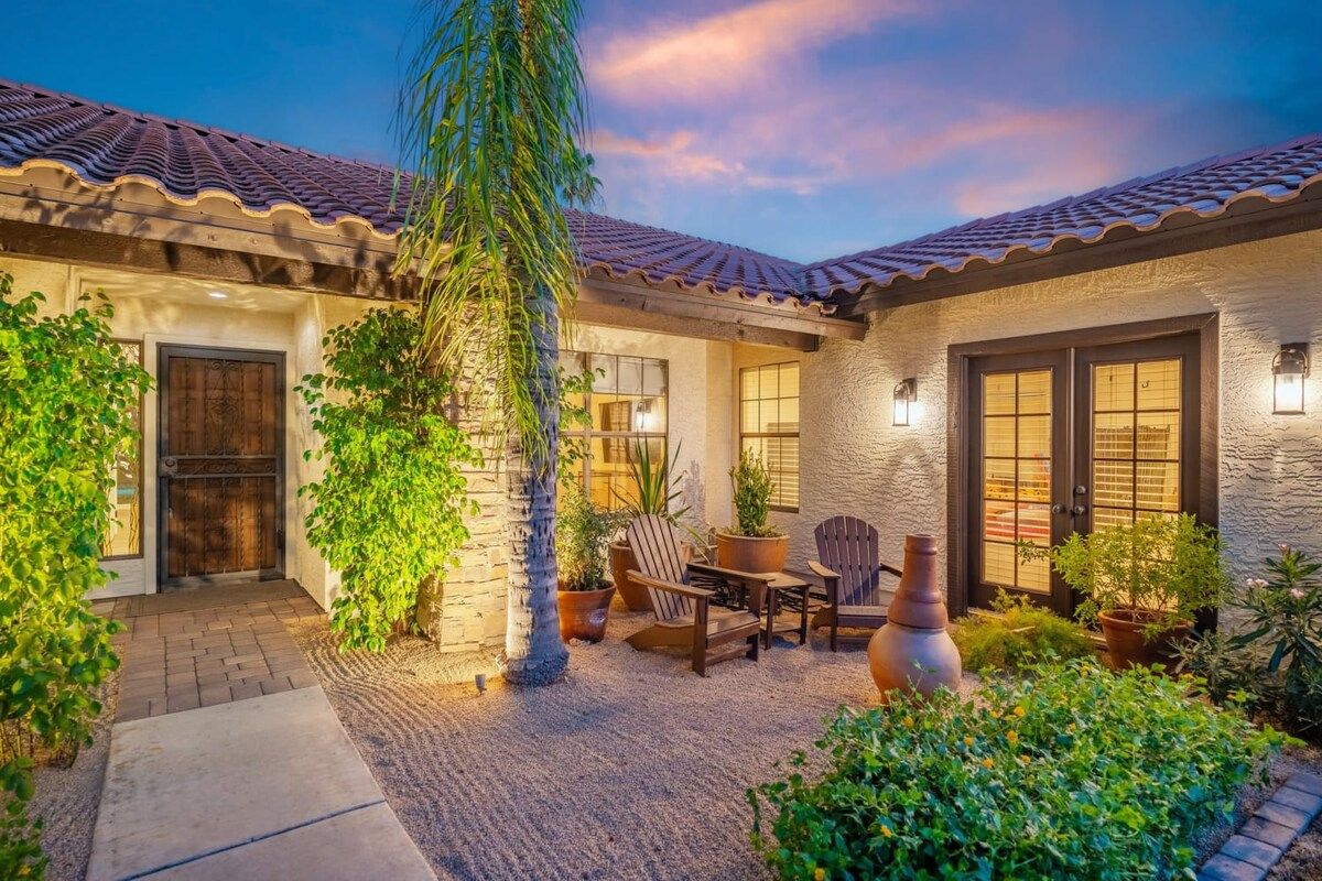 A courtyard with a patio, seating area, and potted plants.