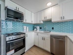 A modern kitchen with white cabinets, a stainless steel stove, and a dishwasher. - Stunning Oceanfront 1 Bedroom Condo Yachtsman 1006 (Myrtle Beach)