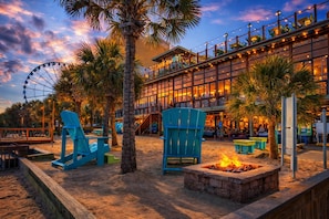 A beachfront hotel with a Ferris wheel, outdoor seating, and a fire pit. - Stunning Oceanfront 1 Bedroom Condo Yachtsman 1006 (Myrtle Beach)