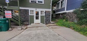 A residential property with a stone facade, a green door, and a visible driveway leading to a front entrance. - Fully Furnished 1-Bed Apartment in Cliff Cannon (Spokane)