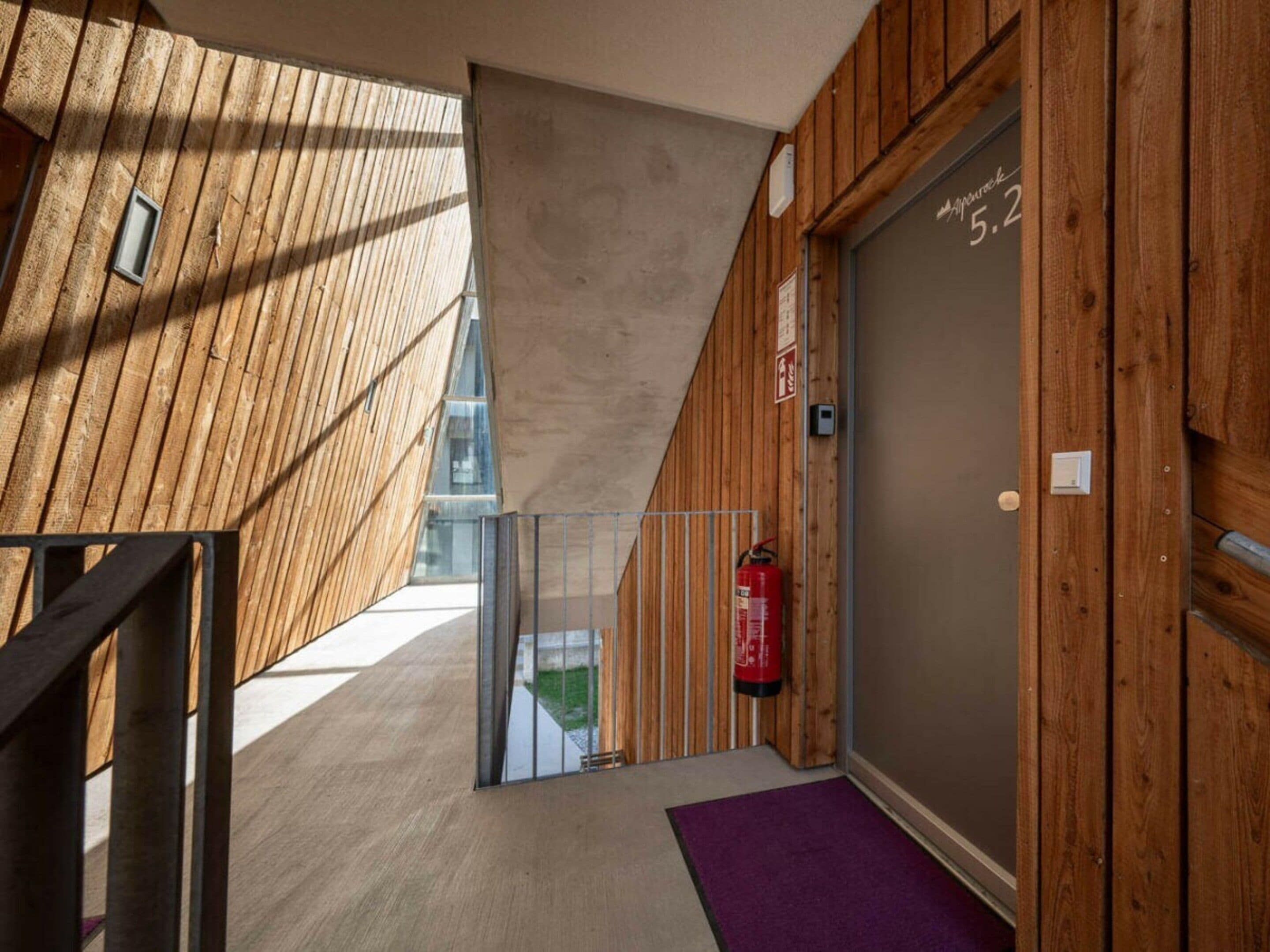 Un interior de madera con una escalera que lleva a una puerta con el número 5.2.