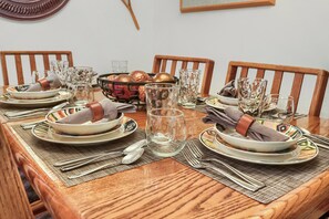 A wooden dining table set with plates, bowls, glasses, and cutlery. - Main Street Walk to Everything and Town Lift 146 (Park City)