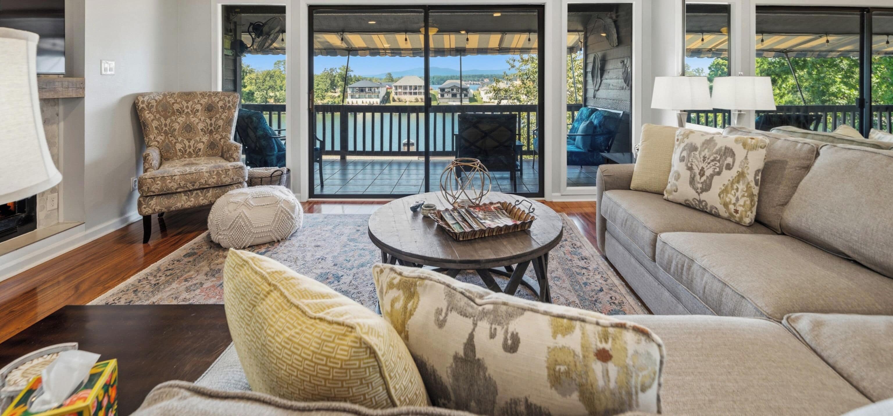 A living room with a sofa, armchair, and a round coffee table with decorative items.