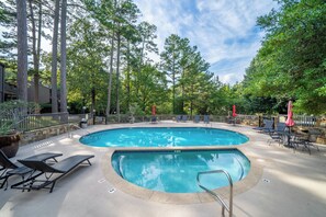 A swimming pool with lounge chairs and umbrellas, surrounded by trees. - Lake Views | Two King Suites | Pool Access (Hot Springs)