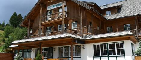 A large wooden building with a sign that reads 'RESIDEN'.