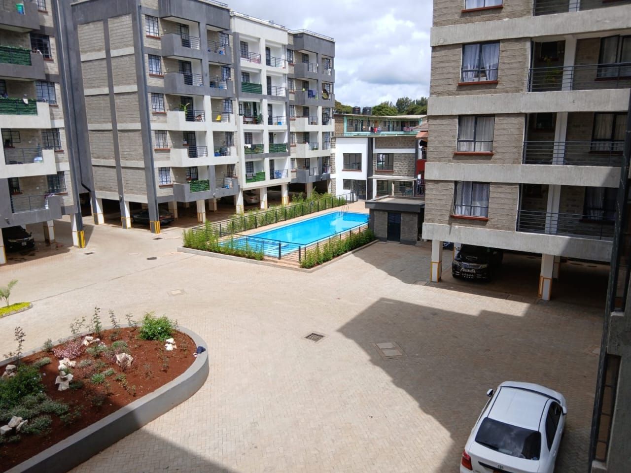 Un edificio residencial de varios pisos con piscina en el patio.