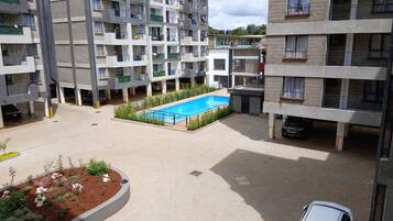 Un edificio residencial de varios pisos con piscina en el patio.