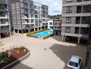 Un edificio residencial de varios pisos con piscina en el patio.